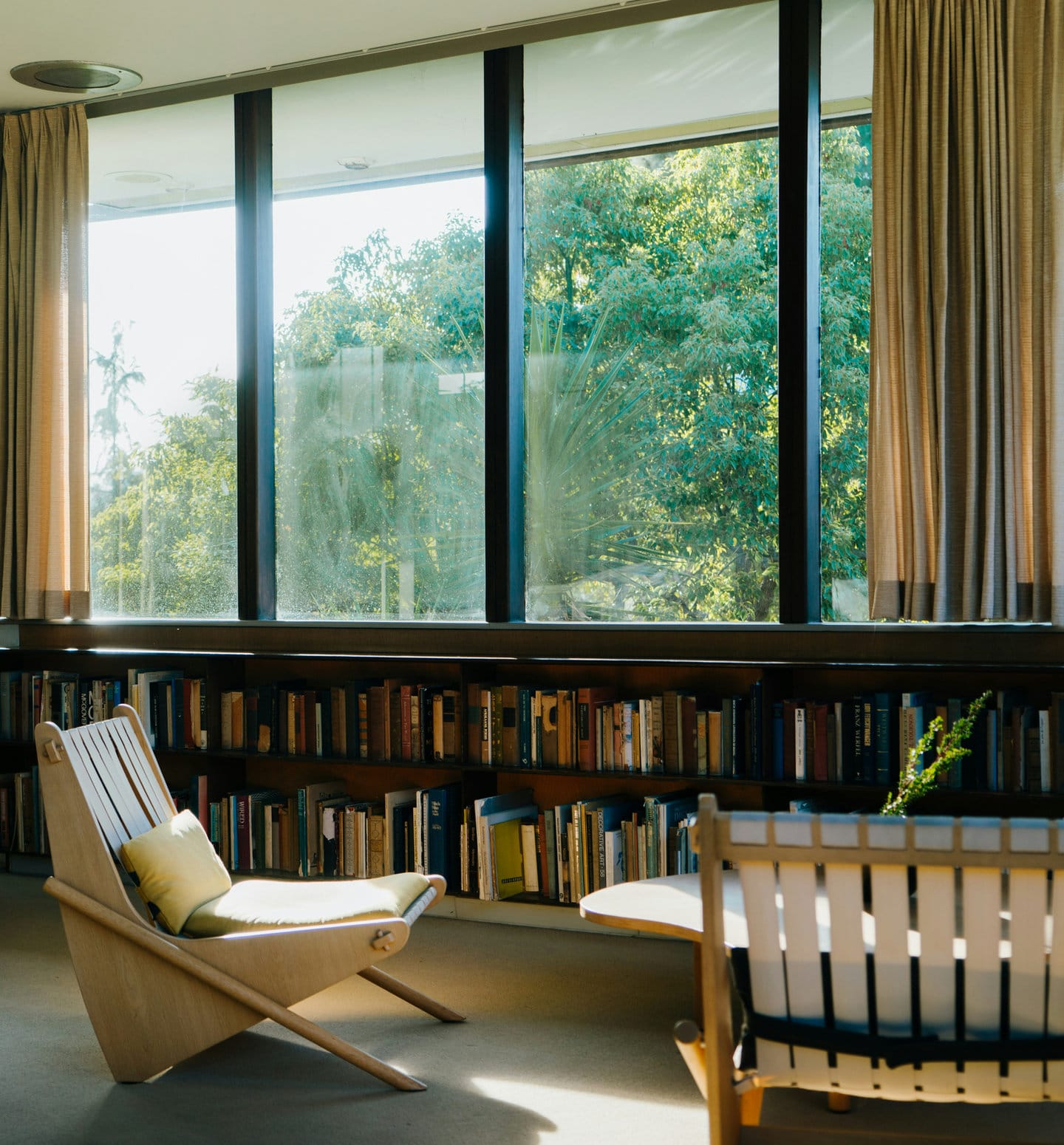 A quiet, light-filled room with books and wooden chairs