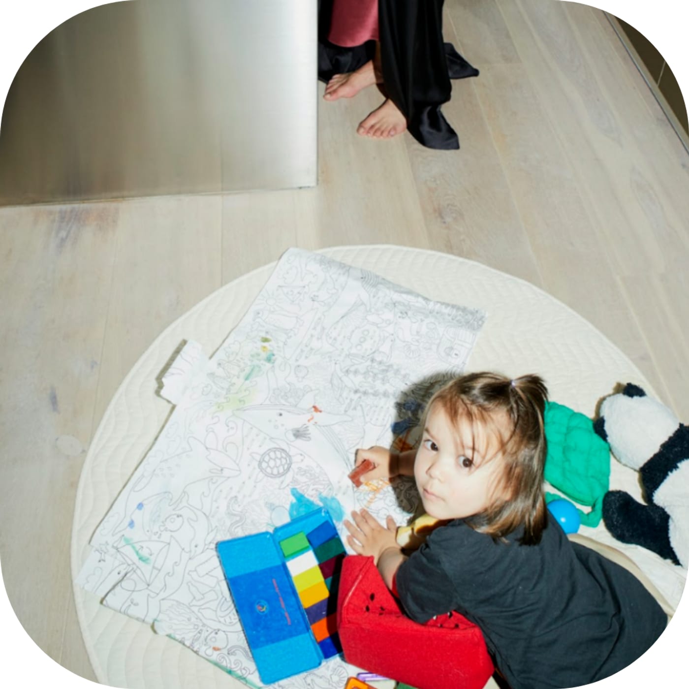 In the image, a child is engaged in play therapy, surrounded by colorful play materials such as stuffed animals and construction toys, demonstrating how play therapists use these tools to enable children to express their feelings and develop problem-solving skills.